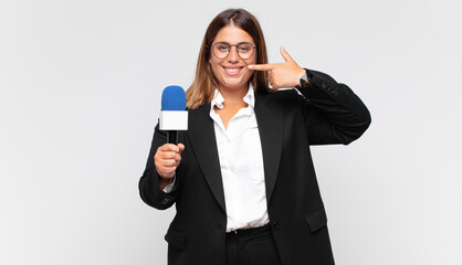 young woman reporter smiling confidently pointing to own broad smile, positive, relaxed, satisfied...