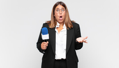 young woman reporter feeling extremely shocked and surprised, anxious and panicking, with a...