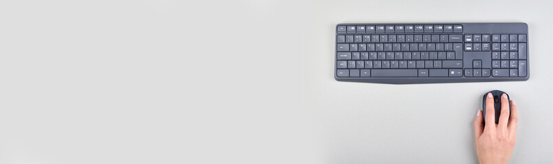 Hand with keyboard and mouse on grey background. Flat lay, overhead view image. Copy space, template.