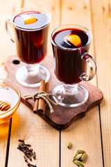 Mulled wine on a wooden boards. Autumn mulled wine, spices and honey. Christmas hot drink in rustic style