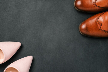 Mens and womens shoes on a black background with a copy of the space. Sale and delivery of shoes from the store, womens and mens fashion