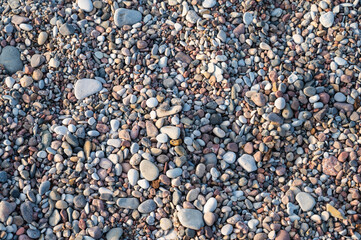 Background of multi-colored pebbles on the sea beach, close up, horizontal orientation