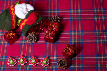 christmas decoration on red background: toy gifts and pine cones and sock with Santa Claus, tinsel and Christmas trees. 2021 new year theme. template for postcards.