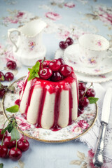 Traditional cherry cheesecake with fruits offered as close-up on design plate