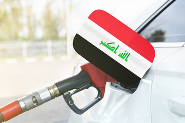 Flag of Iraq on the car's fuel filler flap with gas pump nozzle in the tank.