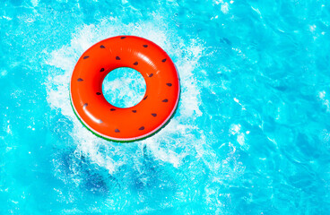 Inflatable red watermelon with seeds buoy splash fall into the swimming pool view from above