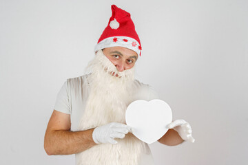 Santa Claus in love offers to take a gift in a box - a heart. Isolated background.