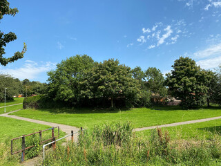 Small bridge, leading into a large field, with old trees, and footpaths, next to local houses near, Meanwood Road, Leeds, UK