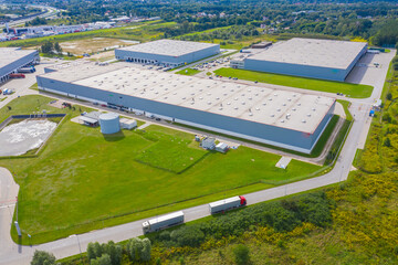 Aerial view of warehouse with trucks driving to the logistic center. Industrial background....