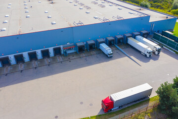 Aerial Shot of Industrial Loading Area where Many Trucks Are Unloading Merchandise.