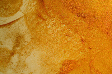 Golden grunge background of shiny paint stains.