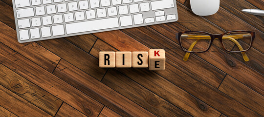 cubes turning message RISK to RISE with office equipment on wooden background