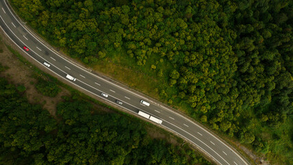 Aerial view over mountain road going through forest landscape