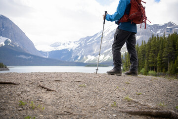 Male hiker with hiking pole at scenic mountain lakeside