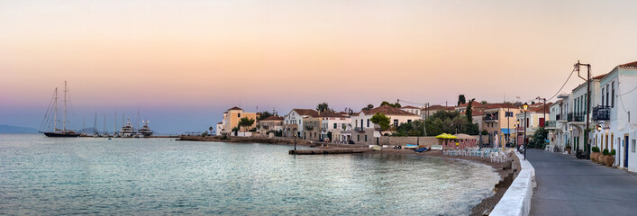 Panoramic view of the coastline, taverns, restaurants and old buildings located on Anargirou street at sunset in Spetses, Greece.