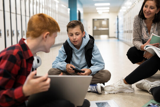 Students using devices in school corridor