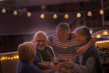 Happy senior people friends enjoy dinner and celebrate in friendship toasting with red wine in...