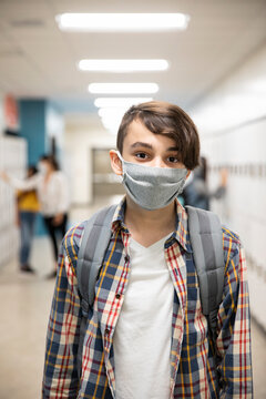 Student in school corridor wearing face mask