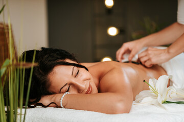 Beautiful young woman in the massage salon with brown curly hair and healthy skin. Masseur and patient concept.