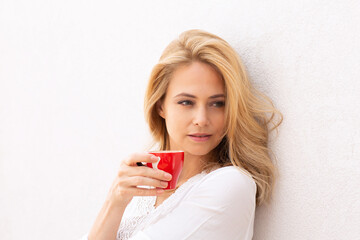Close up of a beautiful blonde woman drinking coffee