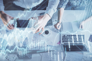 Double exposure of man and woman working together and financial chart hologram drawing. market analysis concept. Computer background. Top View.