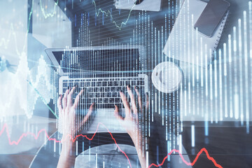 Double exposure of woman hands working on computer and forex chart hologram drawing. Top View. Financial analysis concept.