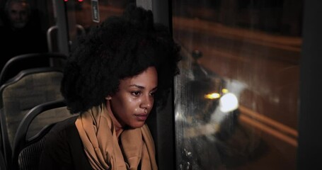 Sad african-american woman sitting on public bus crying wiping tears