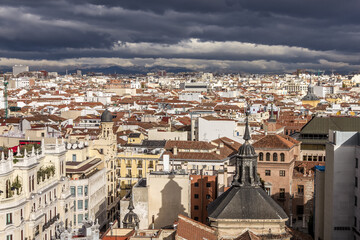 Fototapeta na wymiar Red rooftops and various vintage buildings in urban Madrid Spain with cloudy sky