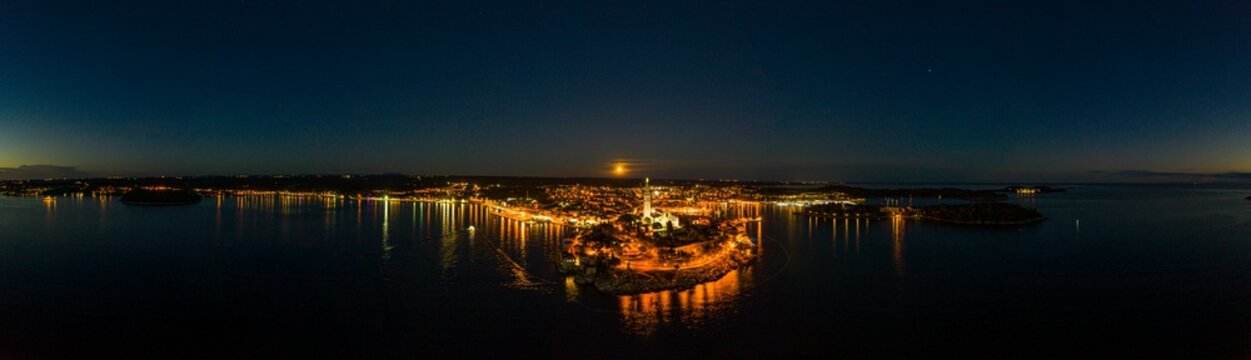 Panoramic aerial drone picture of the historic city Rovinj and harbor with full moon in Croatia during sunset