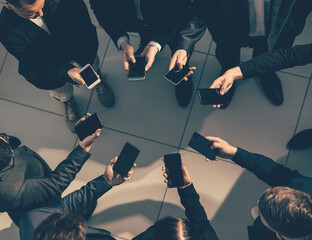 Fototapeta na wymiar close up. young business people with smartphones standing in a circle.