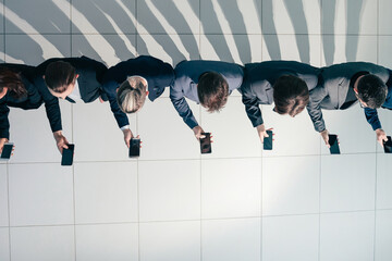 group of young business people looking at their smartphone screens.