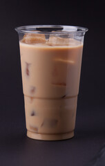A fresh coffee cocktail with milk and ice cubes in a plastic 