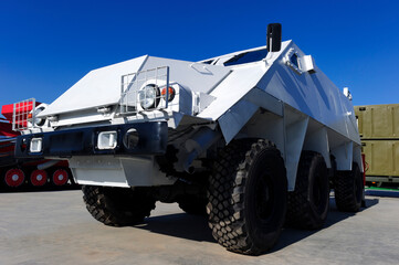 Armored personnel carrier or APC, white military wheeled all-terrain bulletproof vehicle, army industry, other military machines and blue sky on background