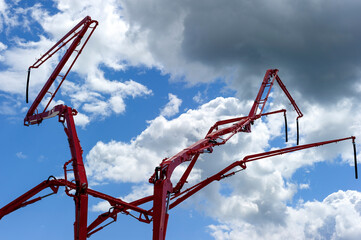 Construction cranes with concrete pumps, heavy industry, blue sky and white clouds on background