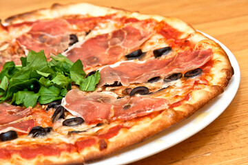 Pizza de Jamón serrano, arúgula,  parmesano, y aceitunas negras
