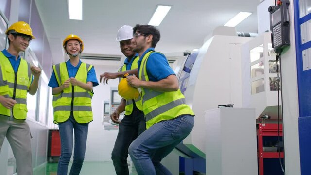 Factory workers man and woman are dancing in workplace area to relax after working. Concept of break after work with relaxation activity that good for industrial staffs.
