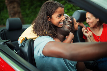 Happy affectionate family in convertible