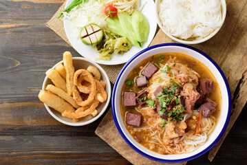 Northern Thai food (Kanom Jeen Nam Ngeaw), Rice noodles spicy soup with pork and pork blood in bowl eating with fresh vegetables and pork rind