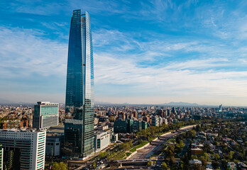 The tallest building in Chile at a sunny day with a park and a river by the side. The financial center of the city 