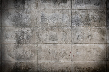 Grunge style. Close-up photo of concrete texture detail, There is a vignette at the corner of the image and a bright spot in the center is a copyspace. The gray and dark cement background is old.