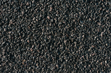 Close-up texture, surface of rough asphalt. Dark gray granular road, top view.