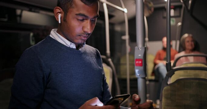 Indian business man working using smartphone on public bus