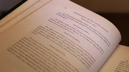 Selective focus on book opening to the Second Amendment to the Constitution of the United States of America, commonly known as the "Right to bear arms"