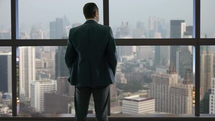 Man with hands in the pocket look out window and admire sky scraper view, above all, powerful businessman