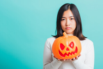 Portrait of Asian beautiful young woman holding orange model pumpkins, funny happy female with...