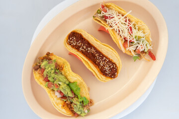 Overhead view of hearty meal of various vegan tacos for vegetarians tempts the taste buds to eat the entire meal.