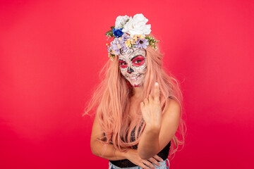 young beautiful woman wearing halloween make up over red background Beckoning come here gesture with hand inviting welcoming happy and smiling