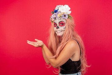 young beautiful woman wearing halloween make up over red background pointing aside with hands open palms showing copy space, presenting advertisement smiling excited happy