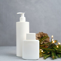 Bottles for cosmetics and Christmas decoration. White blank beauty product containers. Skin, body and hair in Christmas time.