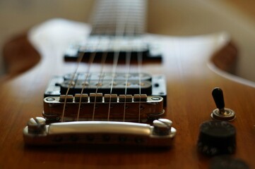 Fototapeta na wymiar Streams and Bridges. Closeup shot of Washburn Idol WI-64 electric guitar with Tune-o-matic bridge
